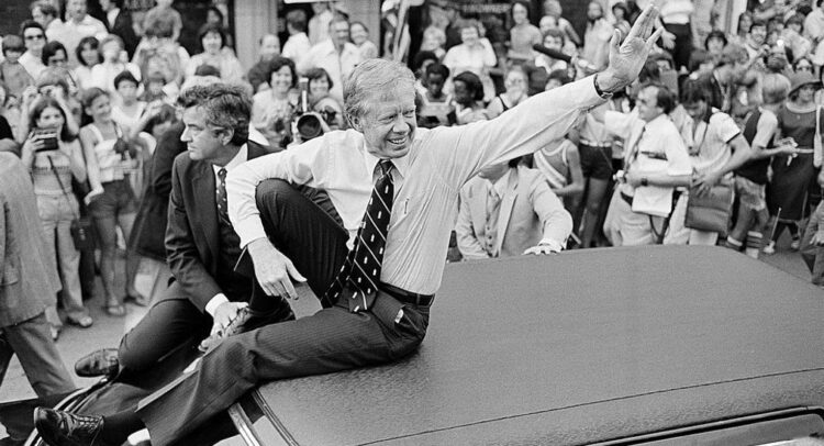 Jimmy Carter sitting on the roof of a car