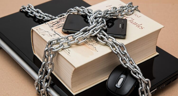 laptop, book and cellphone secured with chain